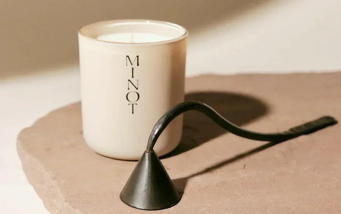 MINOT candle with a candle snuffer in front of it