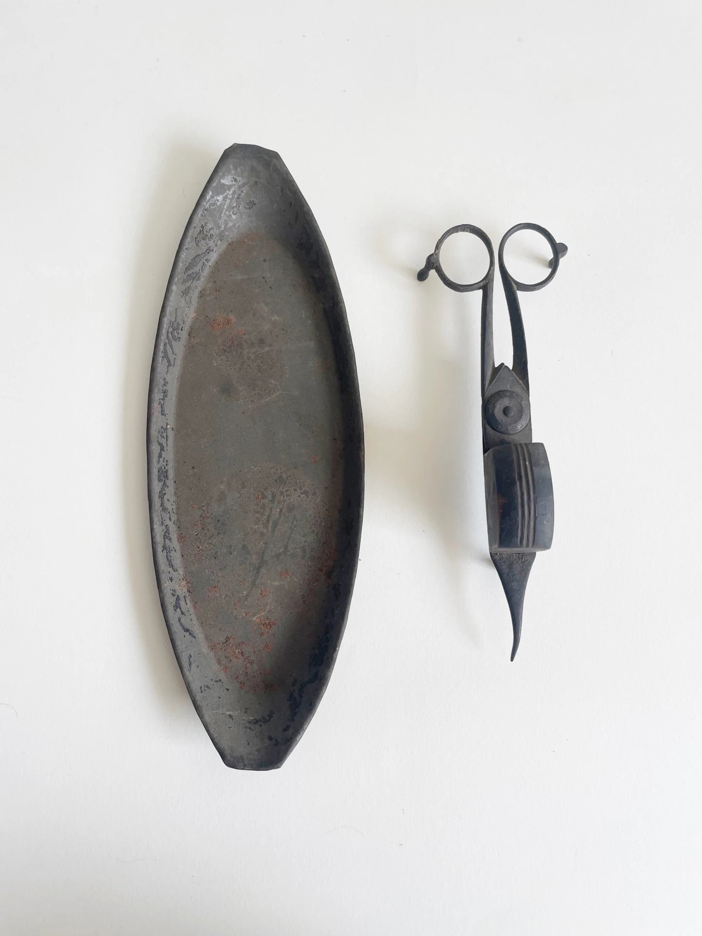 Antique metal candle wick trimmer with a decorative blade and a matching elongated tray on a white background.