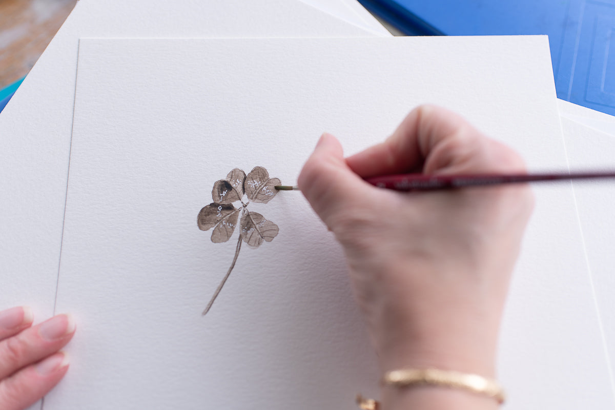 Danielle Driscoll of Finding Silver Pennies paints a watercolor shamrock for the Lucky Charm candle