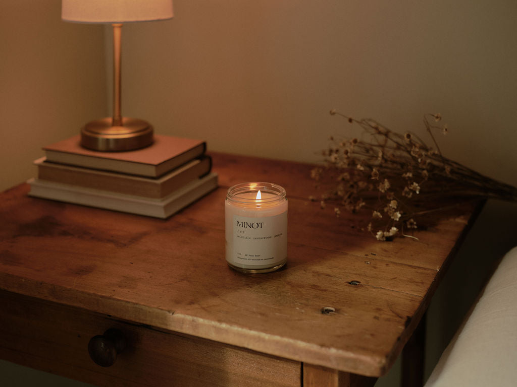 The soy wax 143 I Love You candle sits on a rustic side table with books and dried flowers