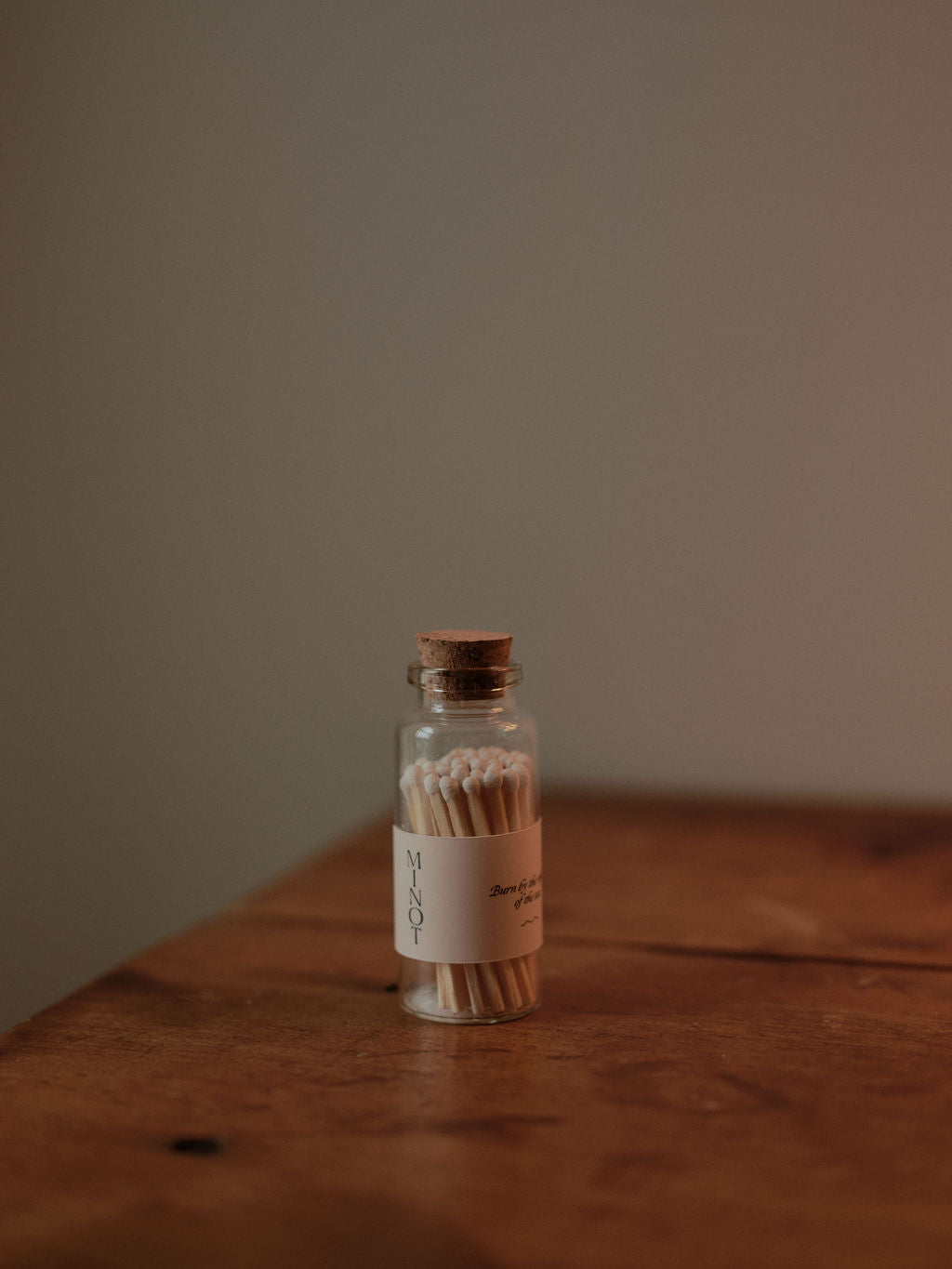 Close up of a small, corked glass bottle containing safety matches with white tips