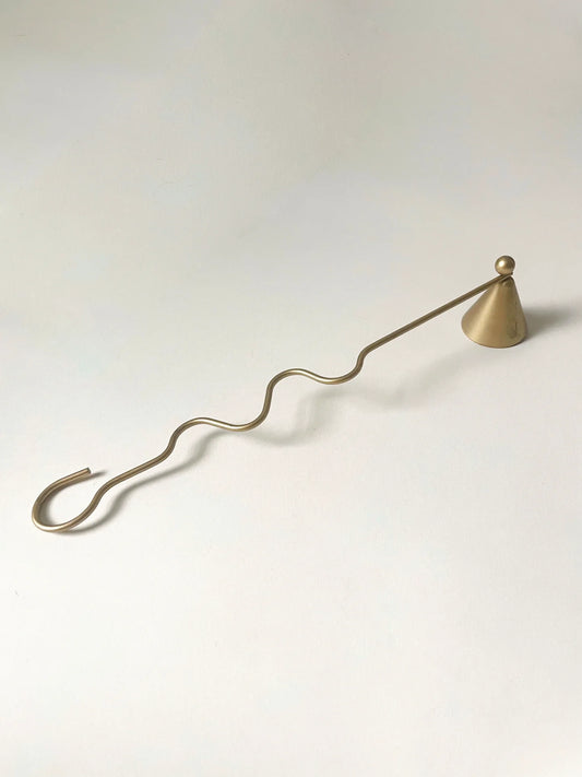 A brass candle snuffer with a wavy, postmodern handle and a sleek, cone-shaped bell and ball on top