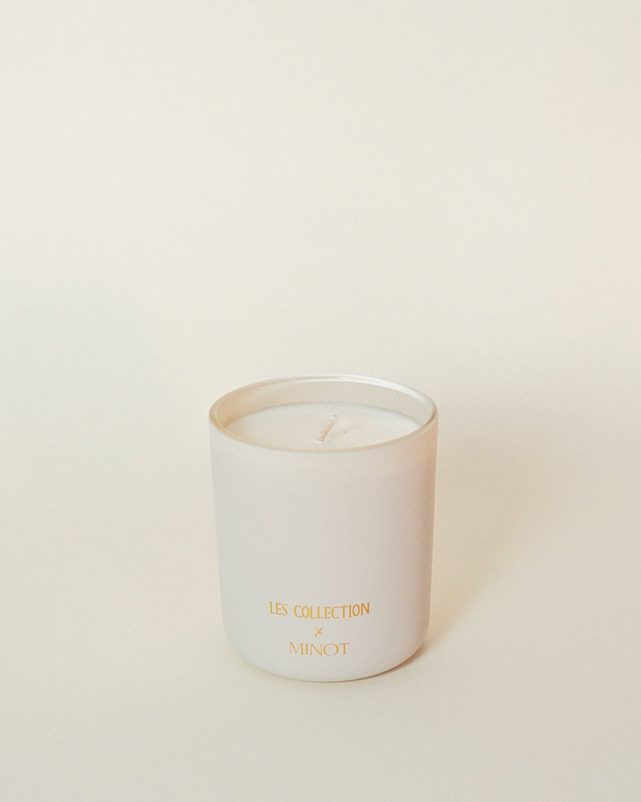 The back of the LES Collection x MINOT candle features both brand logos in gold