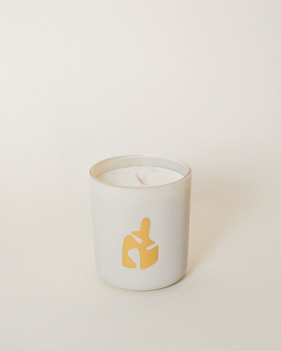 The exclusive LES Collection x MINOT candle features an abstract gold design on the minimalist glass